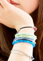Detalle de un brazo con pulseras de una chica